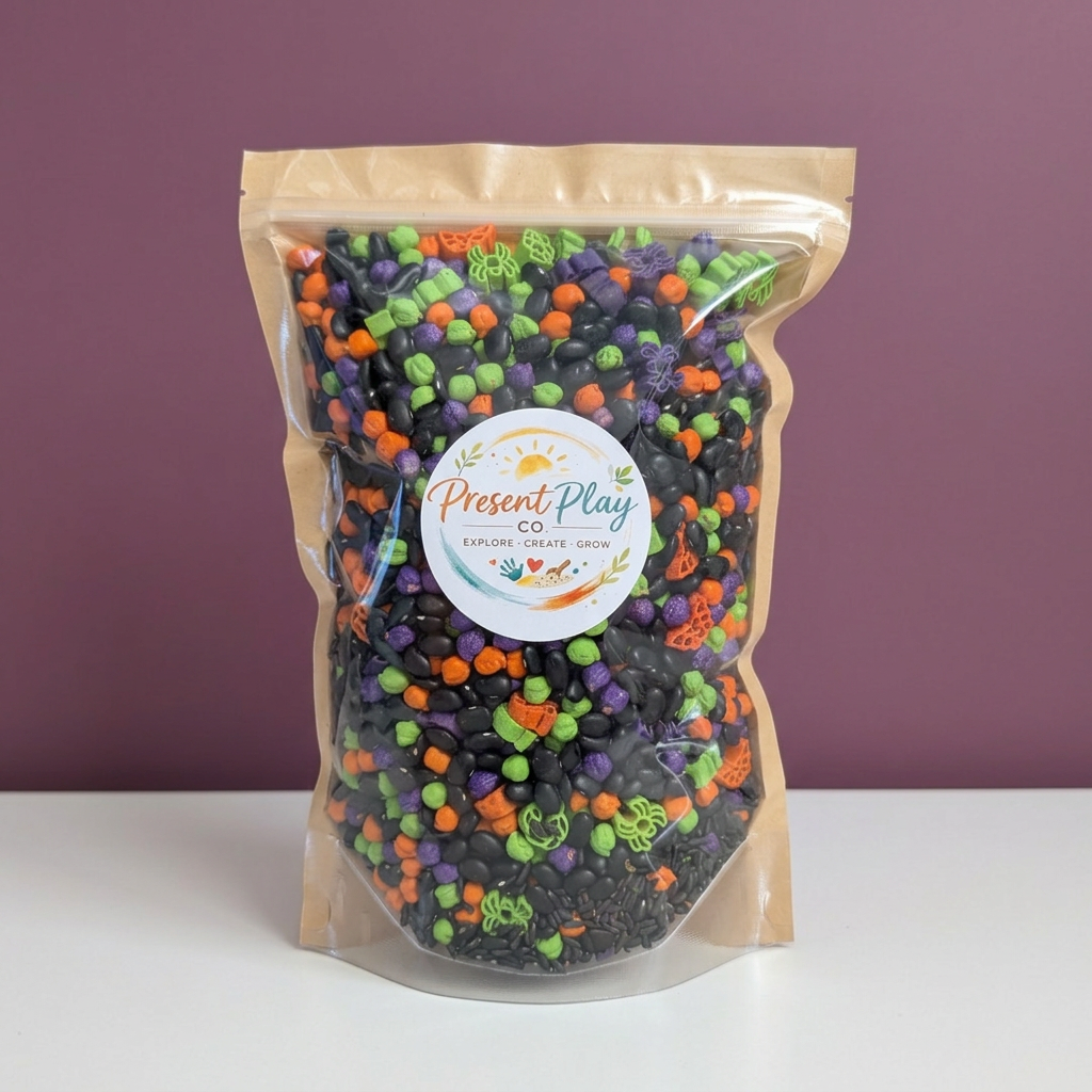Halloween sensory mix in its original Present Play Co. pouch against a muted plum backdrop with a white tabletop